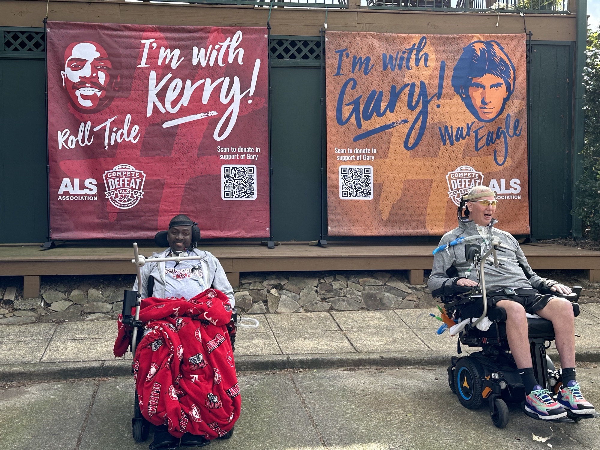Photo of Gary Godfrey and Kerry Goode in front of banners for The Kerry and Gary Challenge